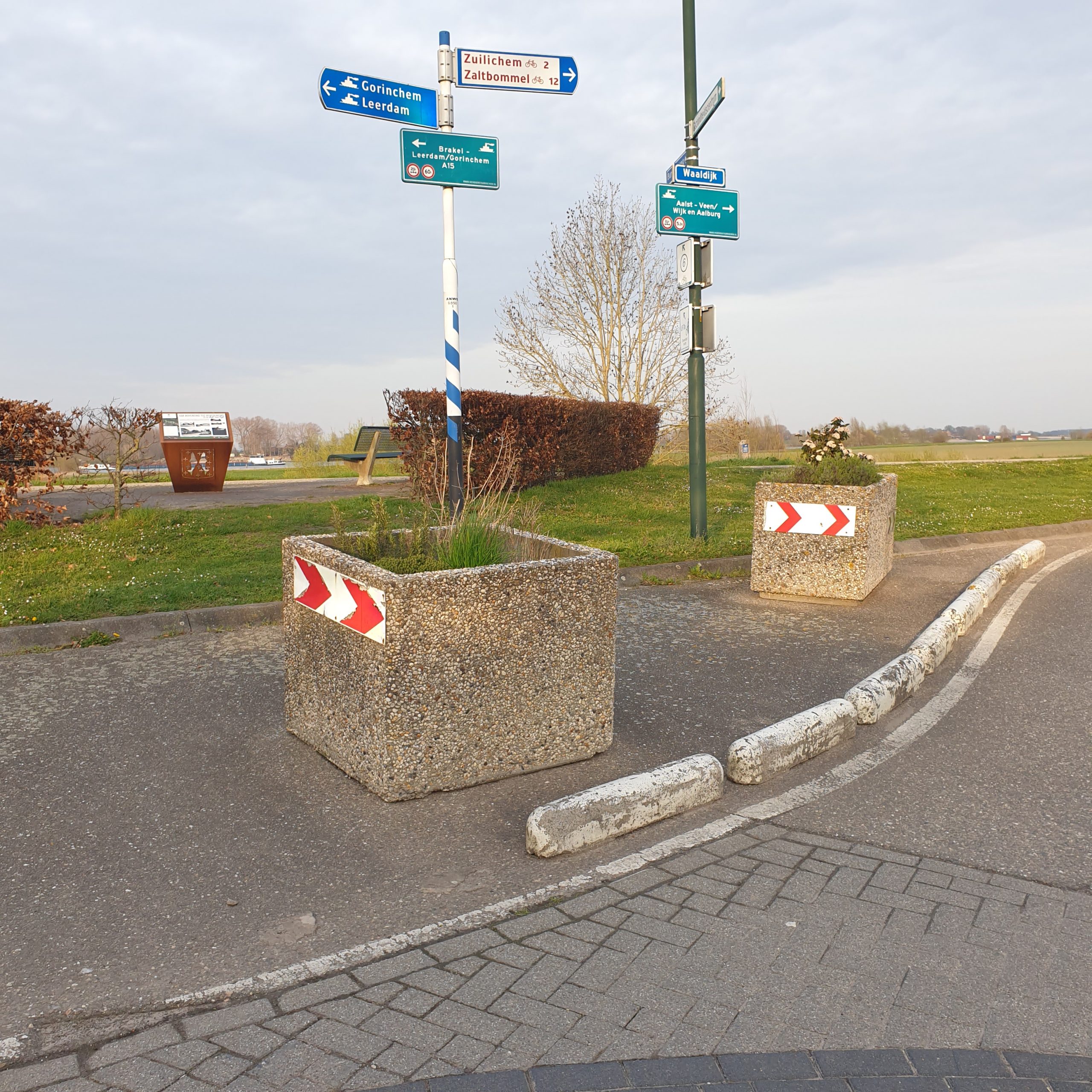 Oude situatie van de terpstoep in Brakel met lelijke grijze betonnen bakken